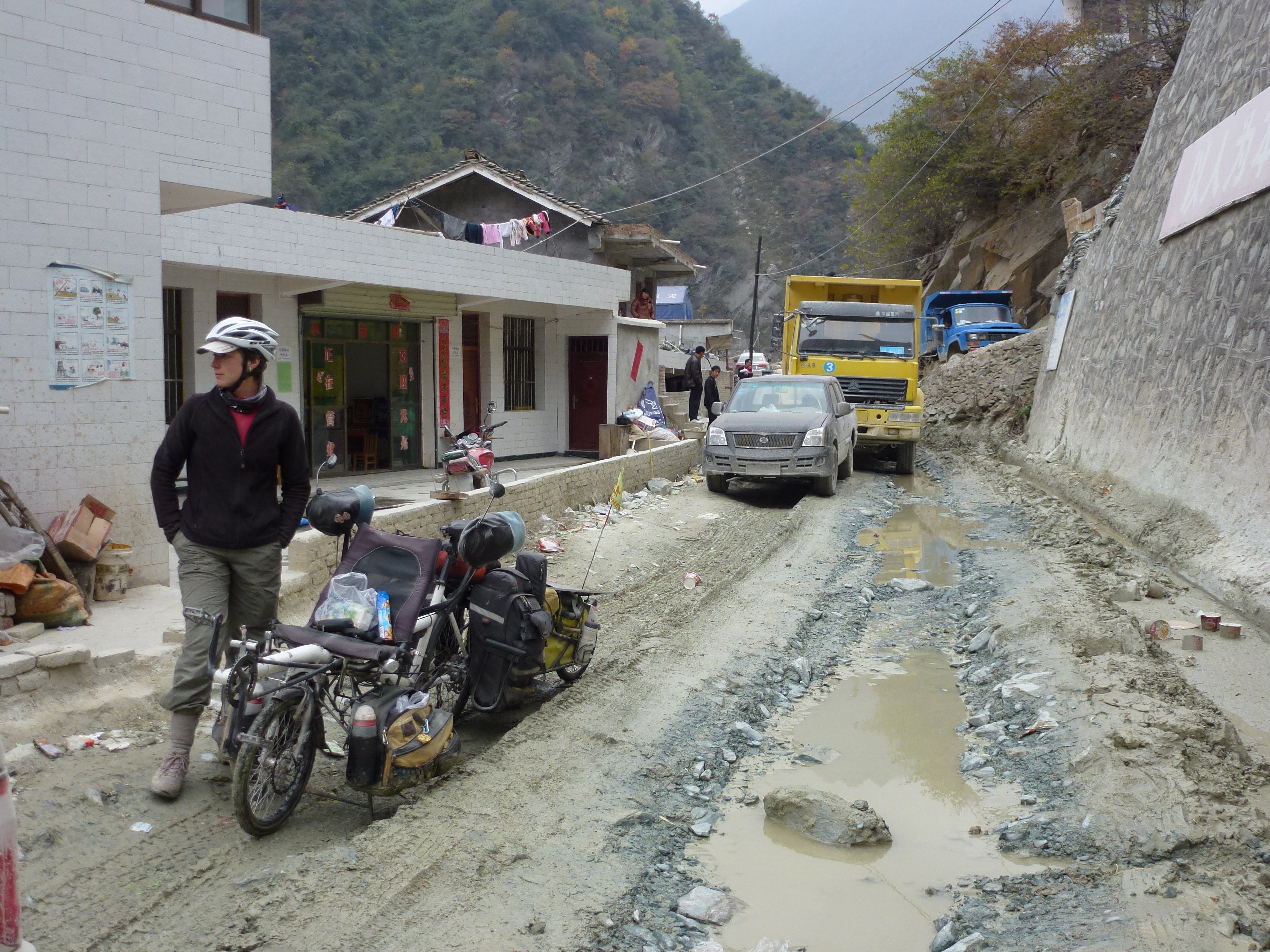 Bored and muddy, waiting for workmen to finish blasting away the cliffside next to the road